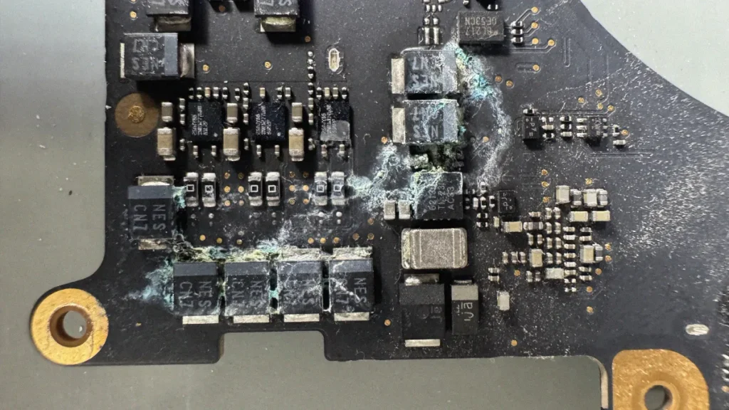 Placa lógica de um Macbook danificada por contato com água.